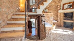 A stone-walled staircase leading to a second floor, a fireplace, and a wooden bench. - SA TEULERA (FORNALUTX) - Fabulous house with stunning views of the Serra de Tramuntana - F (Fornalutx)