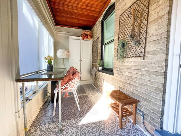 A compact kitchen with a wooden ceiling, a white door, and a window with a view.