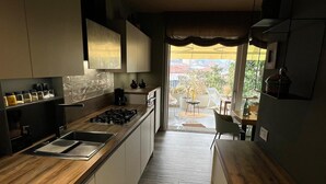 Een moderne keuken met een centraal eiland, een inbouwoven en uitzicht op een balkon.