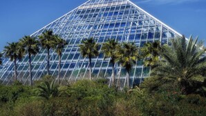 A large glass pyramid structure with a clear sky in the background. - Get ready to soak up the sun at Villa Caman! (Galveston)