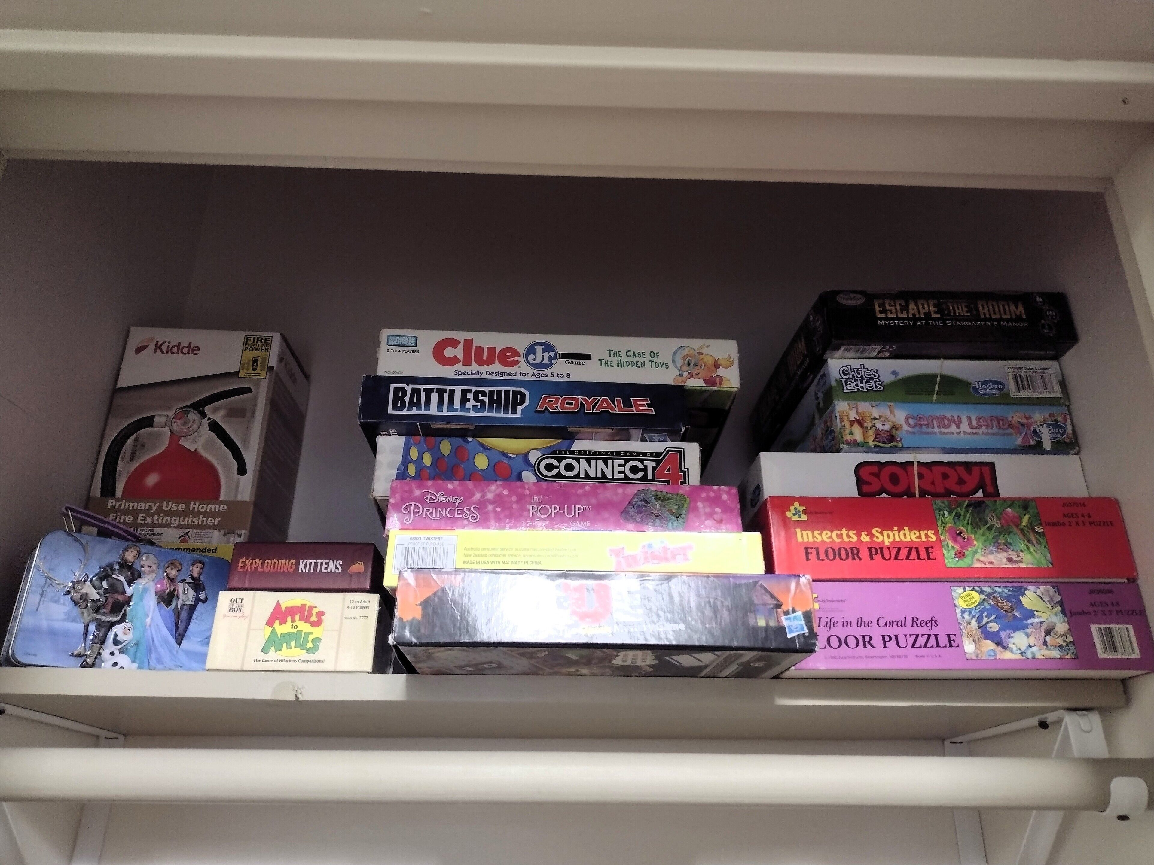 A shelf with various board games and puzzles.