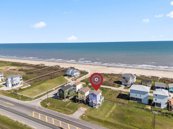 Ein Küstenwohngebiet mit Häusern, einer Straße und einem Strand.