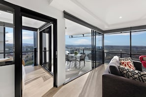 A modern apartment with a balcony, large windows, and a city view. - Circle on Cavill River View (Surfers Paradise)