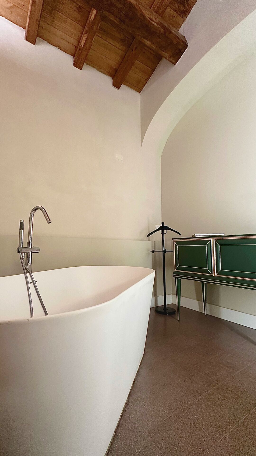 A bathroom with a freestanding bathtub, a towel rack, and a bench.