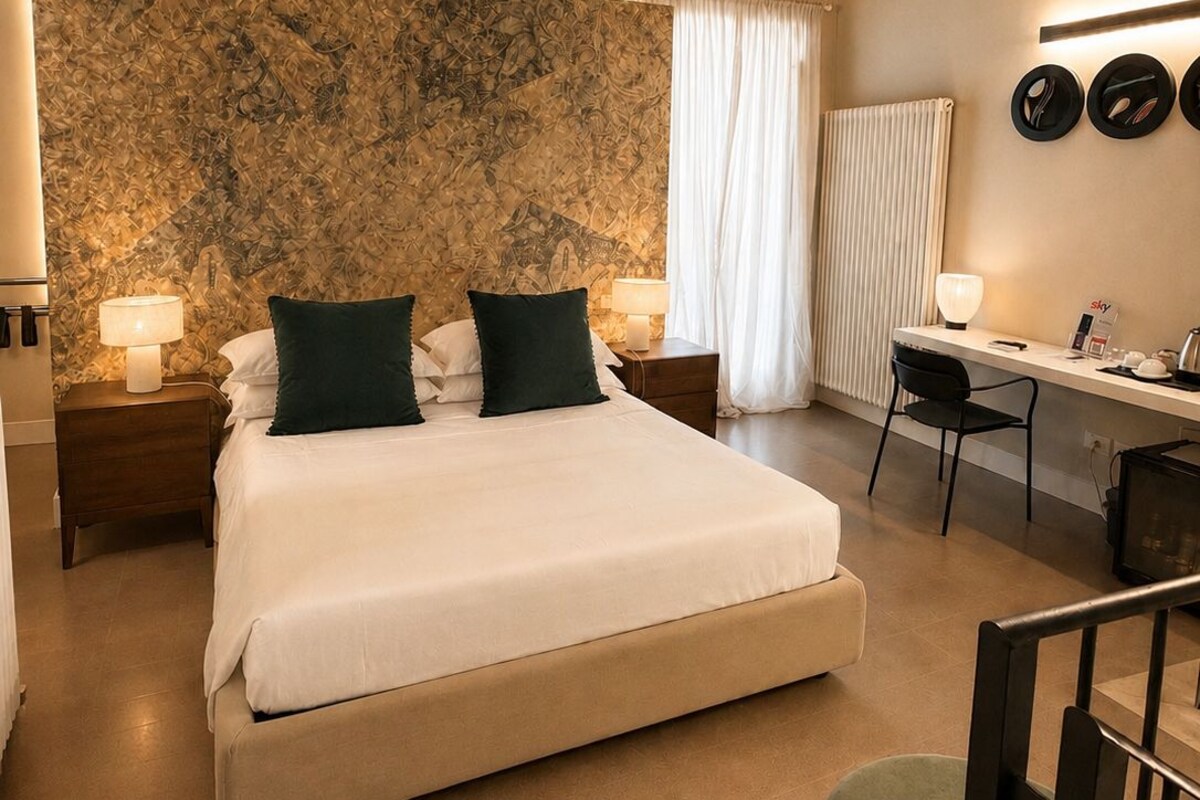 Une chambre à coucher avec un lit, des tables de chevet, un bureau et une chaise.