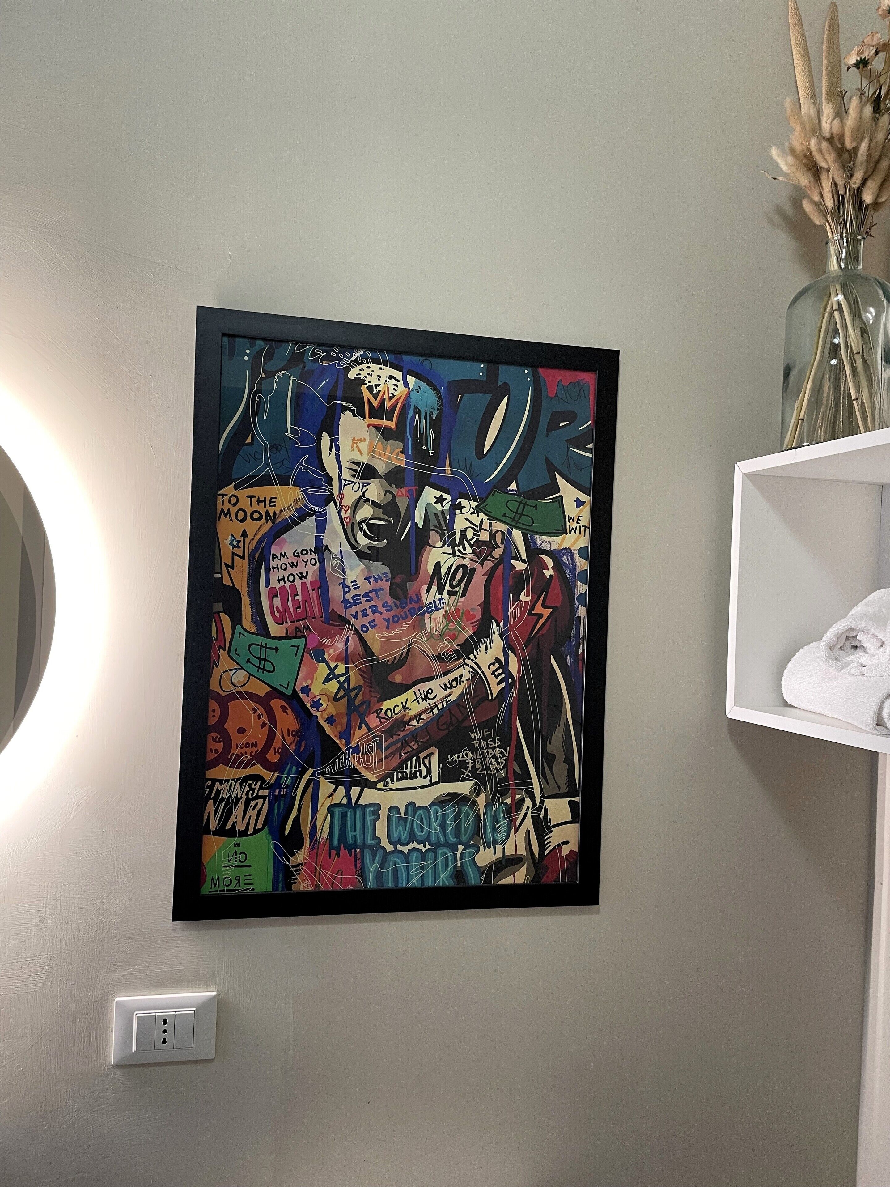 A framed artwork with various text and symbols on a wall.