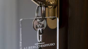 En nyckelring med namnet ”Albergodiffuso Grey” fäst vid ett dörrlås.