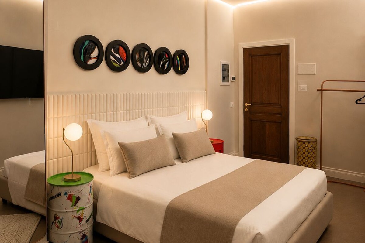 Une chambre moderne avec un grand lit, des lampes de chevet, un téléviseur à écran plat et une porte.