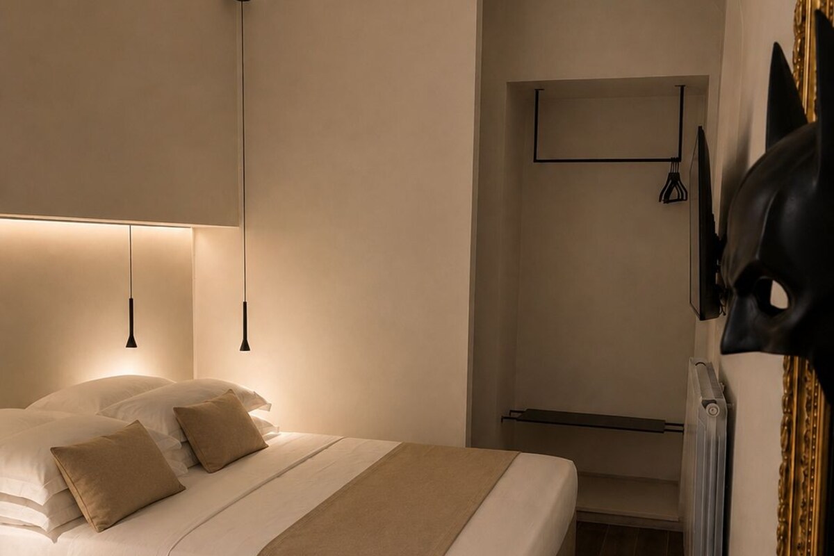 Une chambre à coucher moderne avec un lit, des lampes de chevet, un radiateur et une étagère fixée au mur.
