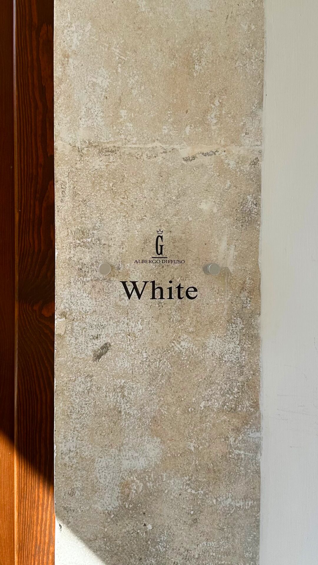 A textured wall with a logo and the word 'White' indicating a product or brand name.