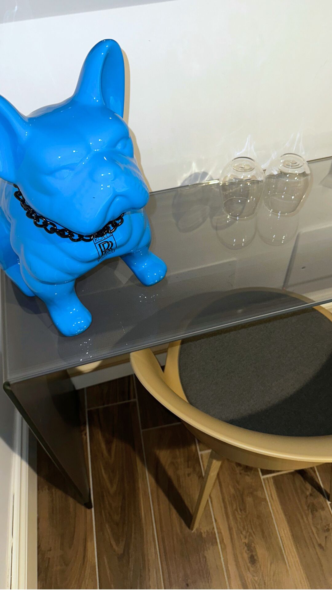 A blue elephant-shaped object on a table next to a glassware set.
