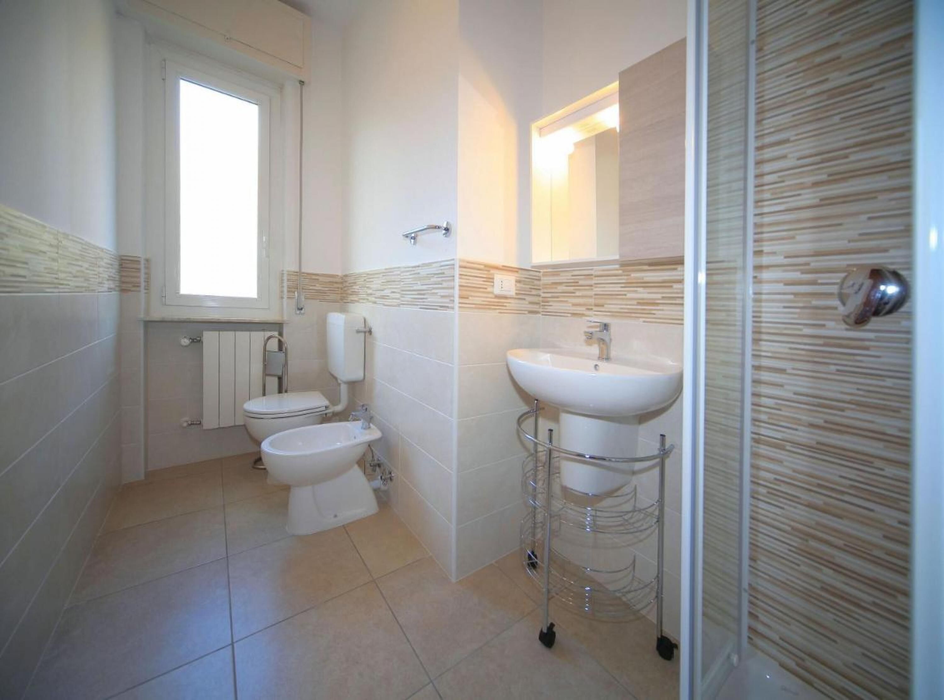 A bathroom with a toilet, bidet, and sink.