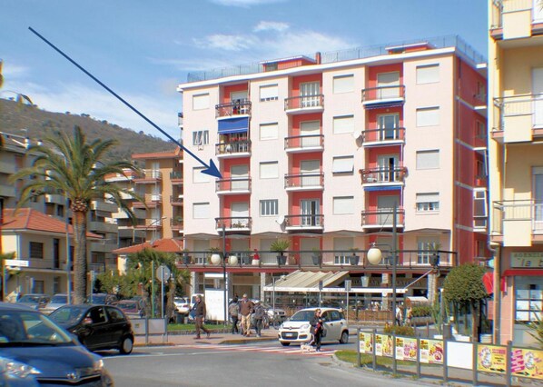 Un hôtel à plusieurs étages doté de balcons, d’un parking et donnant sur la rue.