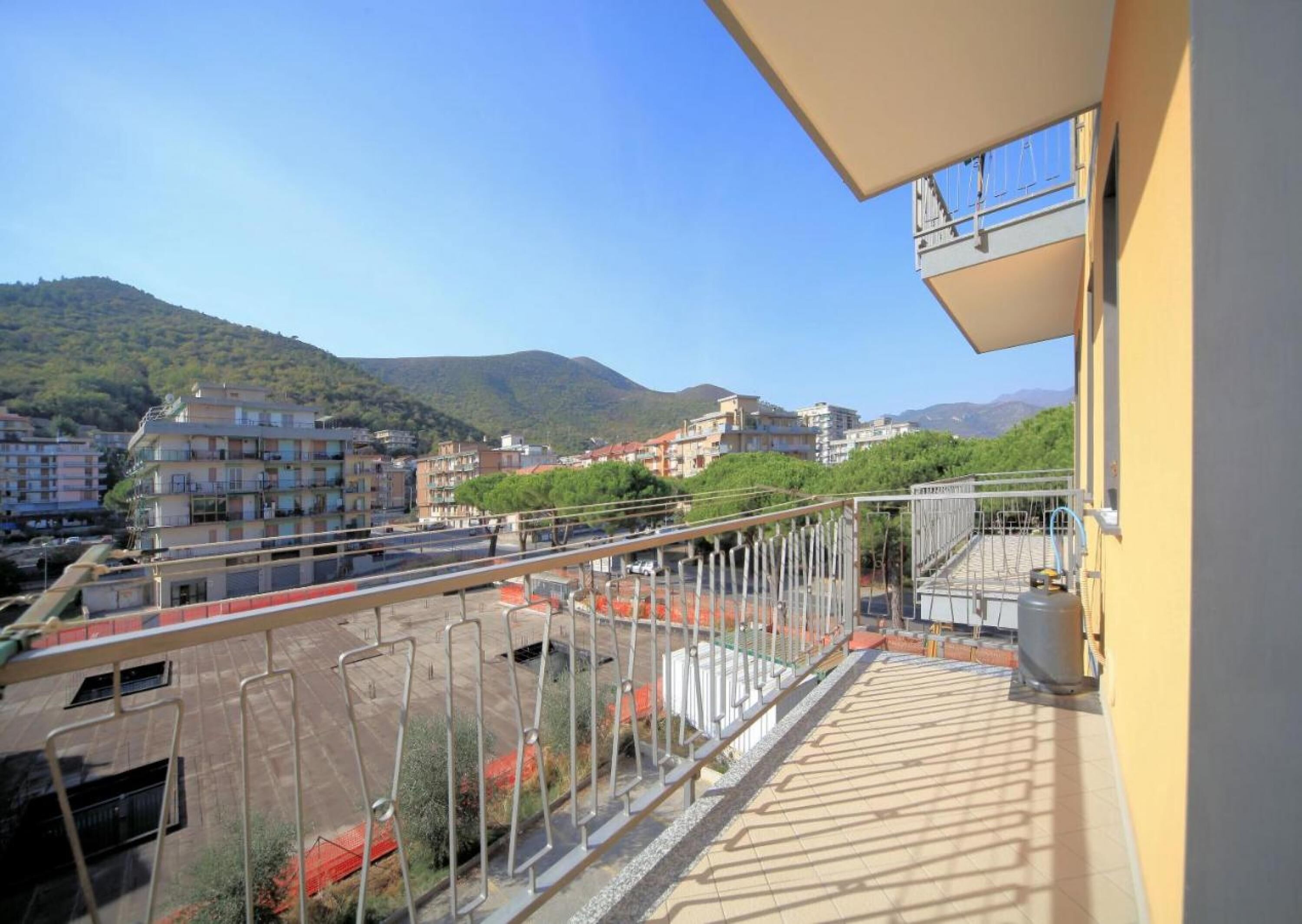 A balcony with a view of a cityscape and mountains.