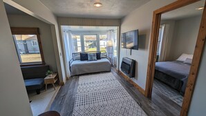 A bedroom with a bed, a TV, and a window.