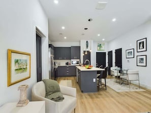 A modern apartment with a kitchen, dining area, and living room.
