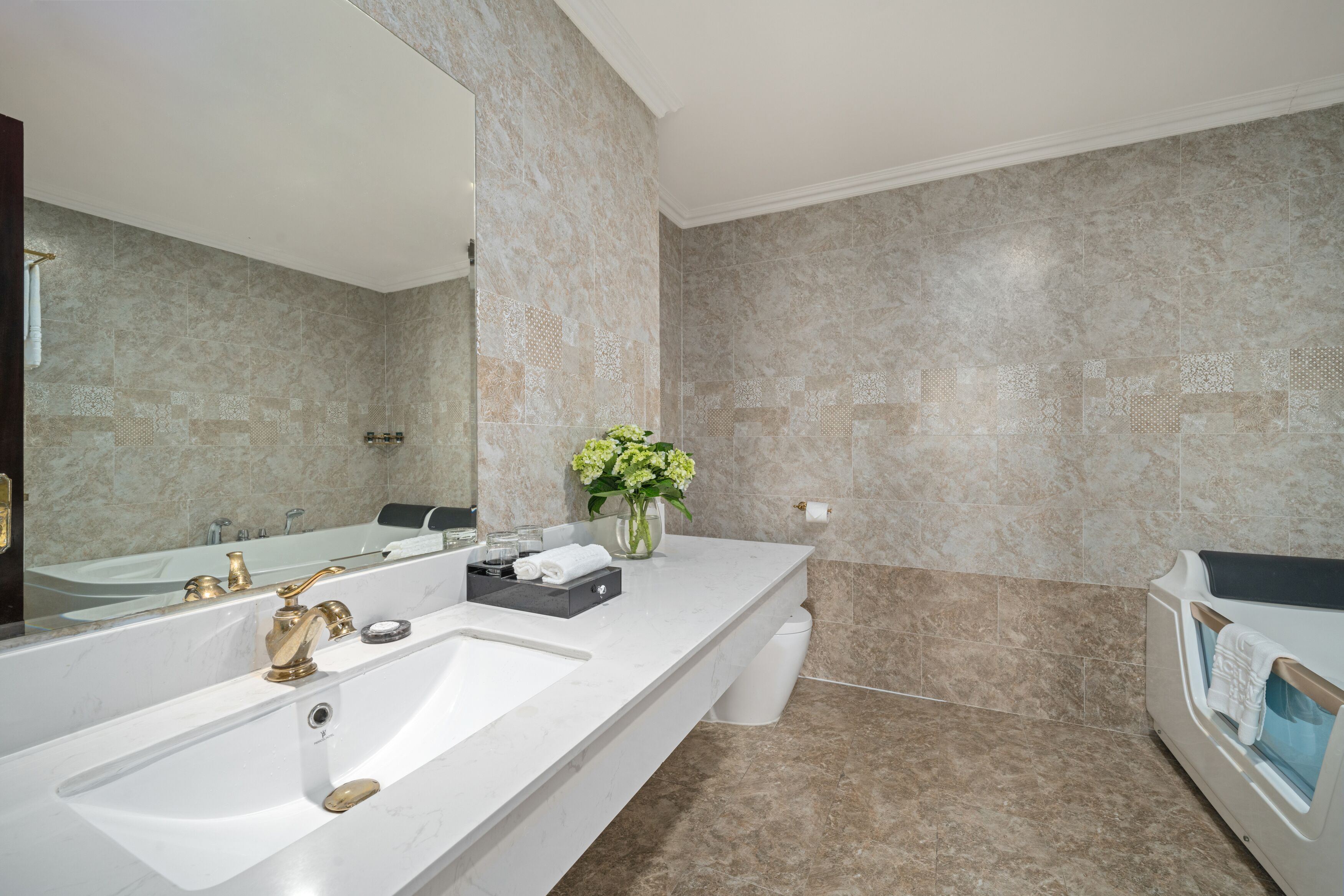 A modern bathroom with a large sink, a bathtub, and a mirror.