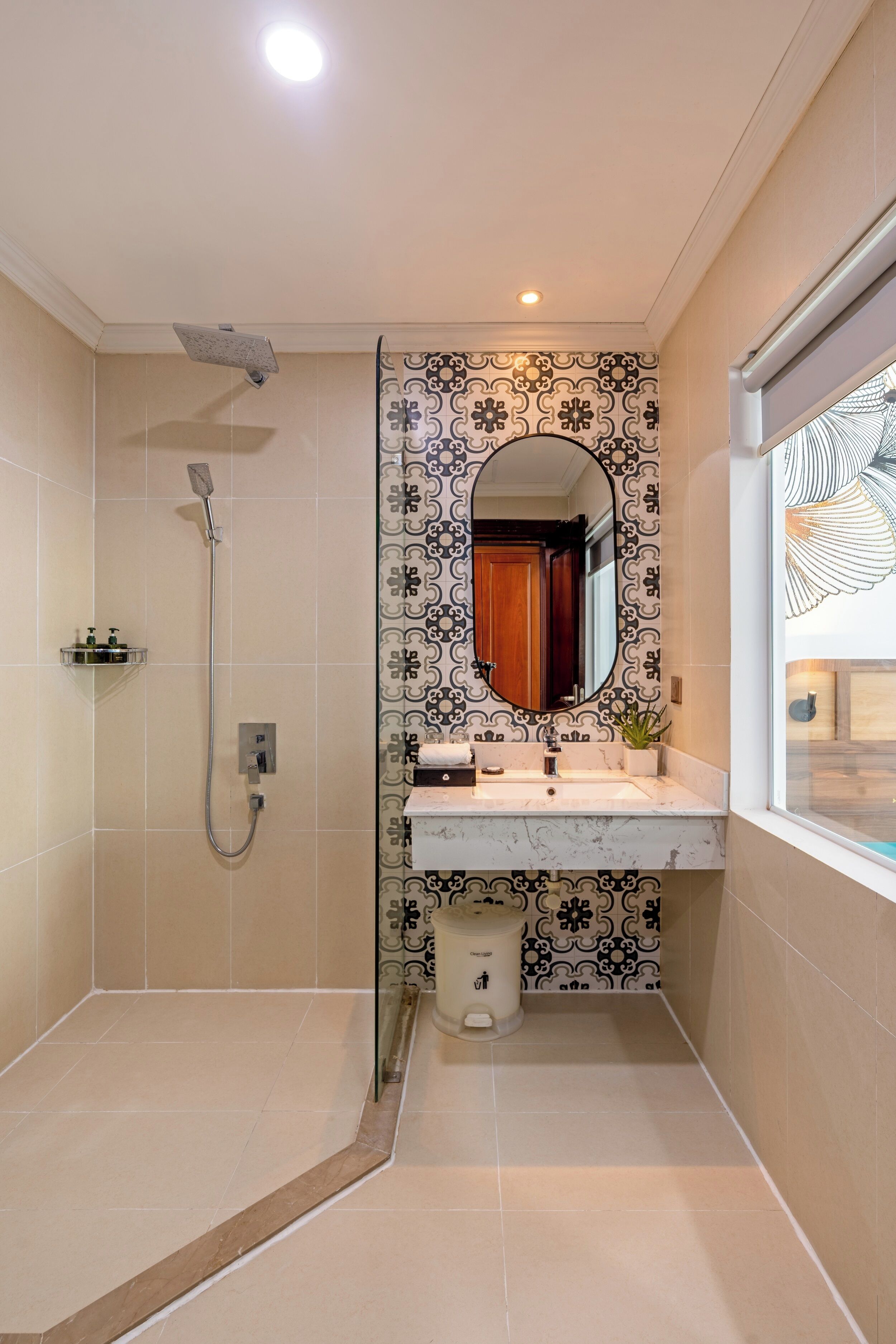 Un baño con ducha, lavamanos, espejo y ventana.