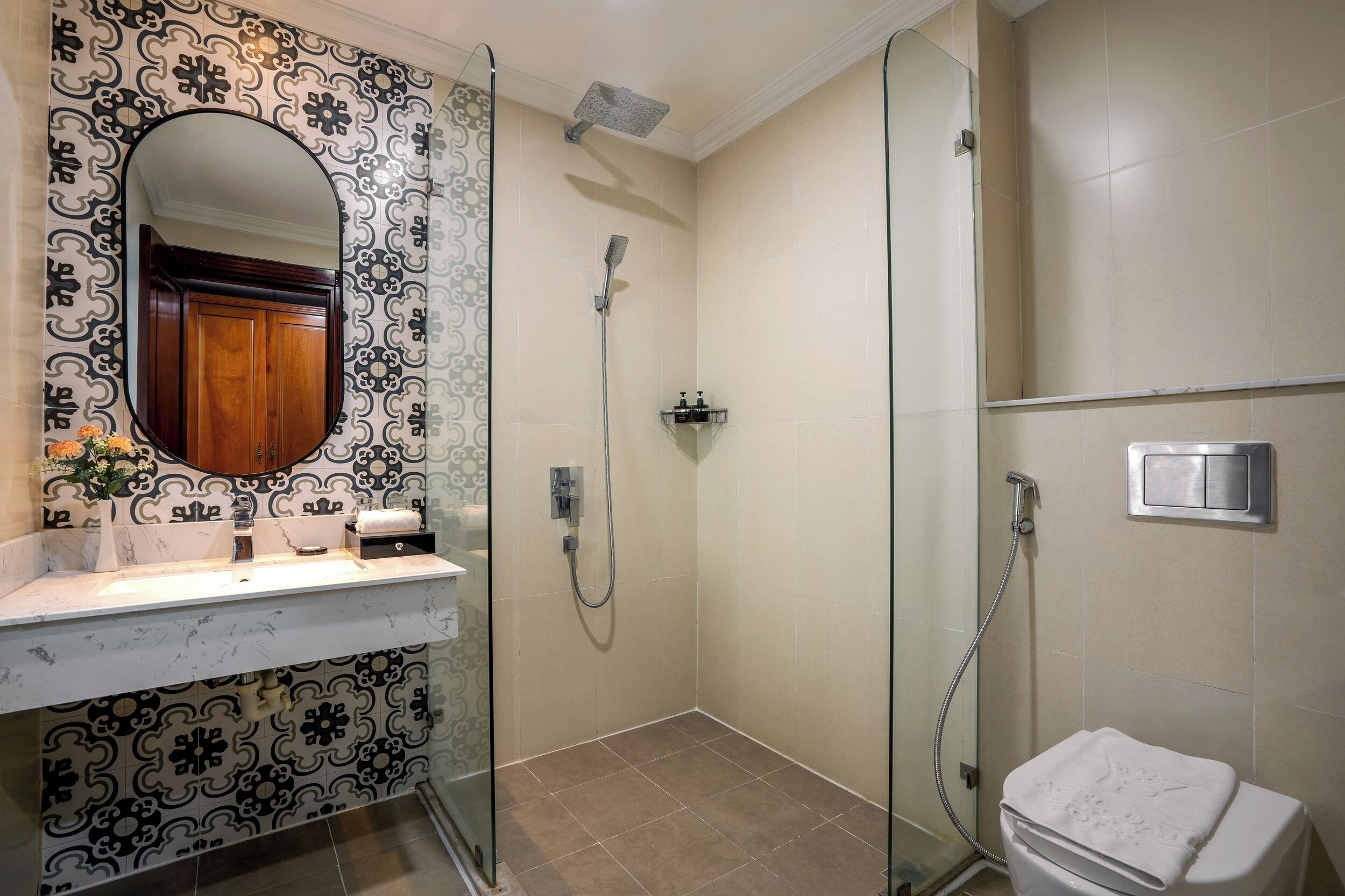 A bathroom with a shower, a sink with a mirror, and a toilet.