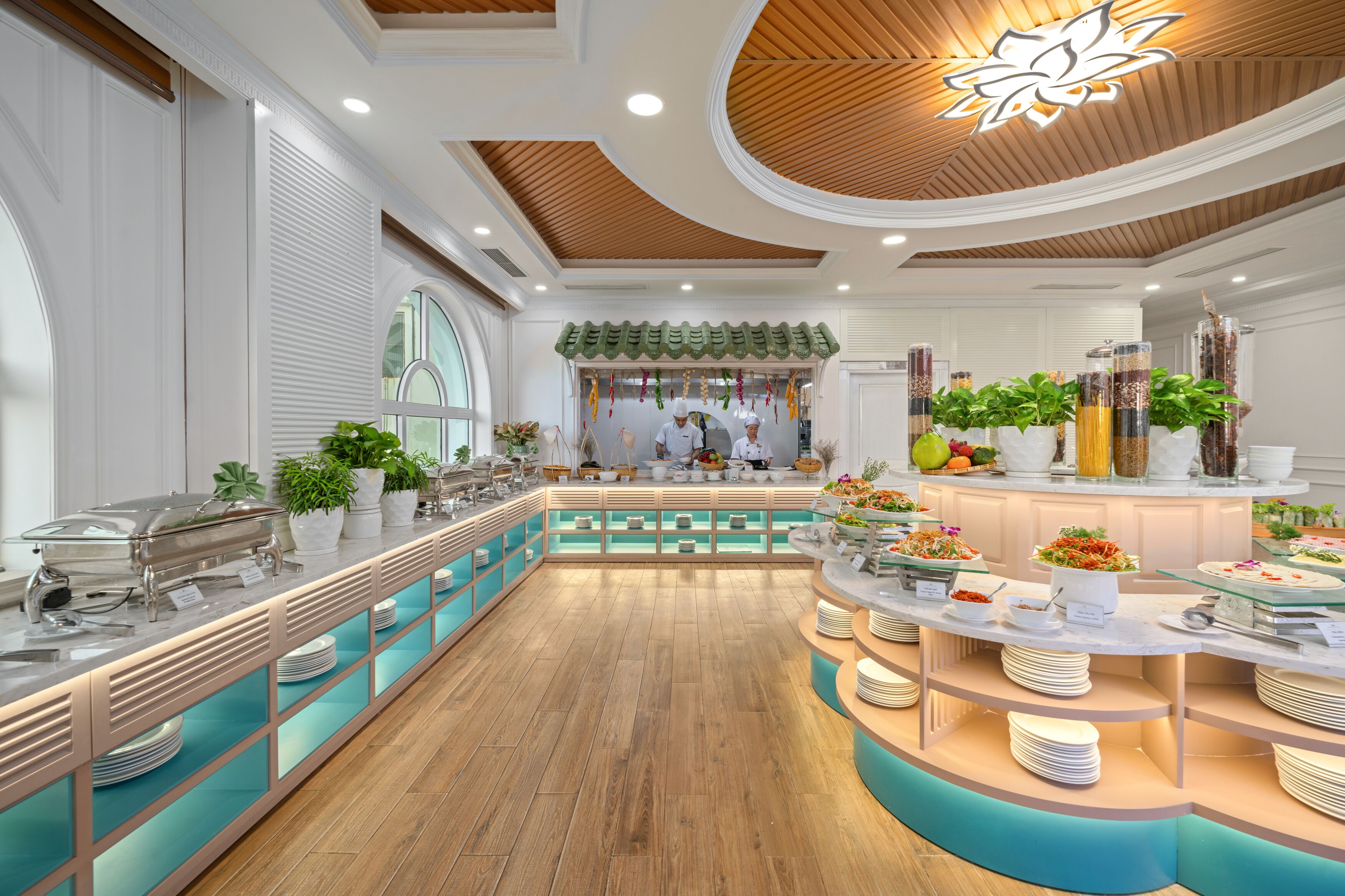 Un'area buffet con diverse postazioni di servizio, un'isola centrale e una varietà di cibi esposti.