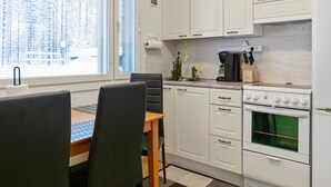 Une cuisine moderne avec des meubles blancs, une cuisinière et une machine à café.