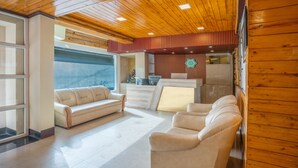 A spacious lobby with a wooden ceiling, a reception desk, and a seating area with two sofas. - Treebo Eeshan Rodhi Resort, Darjeeling (Darjeeling)