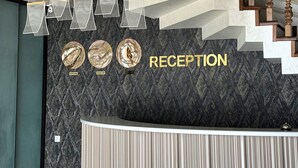 A reception area with a marble wall, a reception desk, and three clocks labeled 'New York,' 'Moscow,' and 'London.' - Colibri Hotel  (Bukhara)