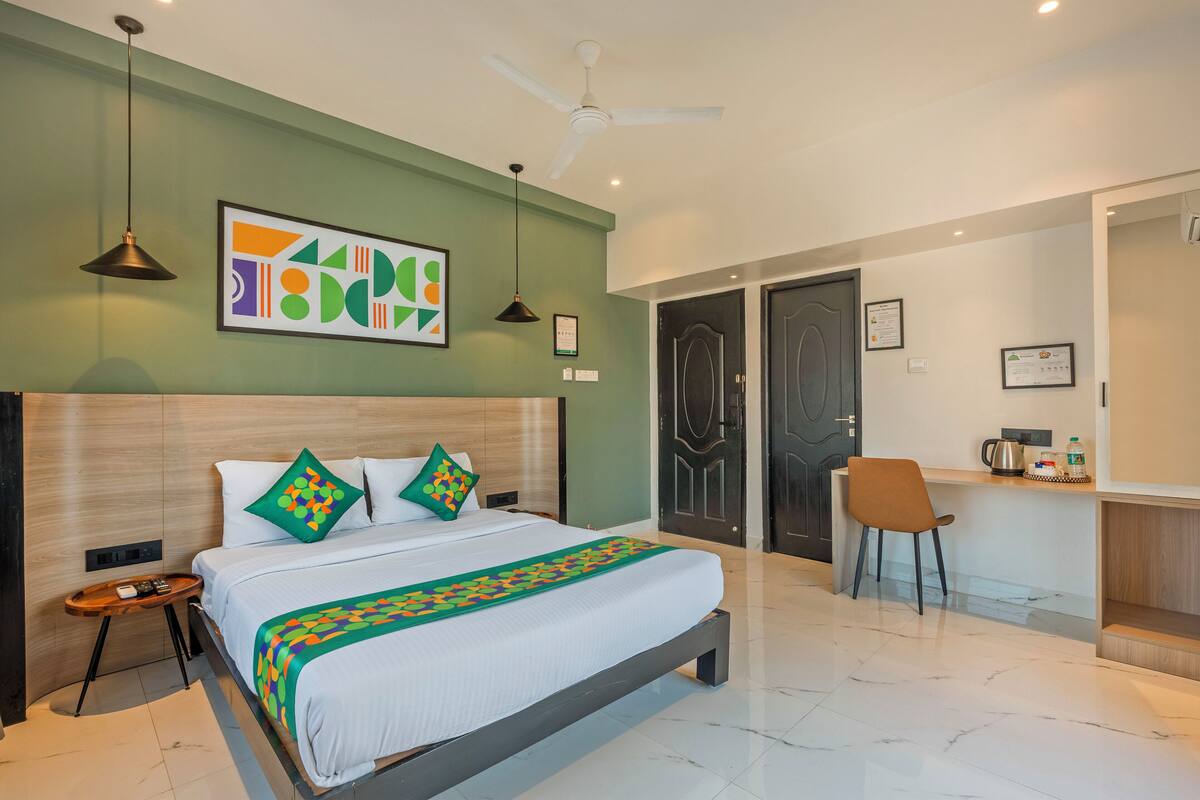 A modern hotel room with a bed, a desk, a chair, and a ceiling fan.