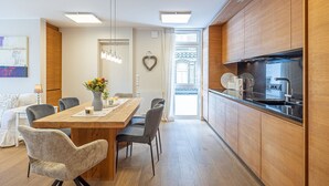 A modern kitchen with wooden cabinets, a black countertop, and a built-in oven.