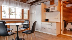 A cozy kitchen with a dining area, wooden floors, and a view of the outdoors. - Rustholli 9 by Interhome (Tampere)