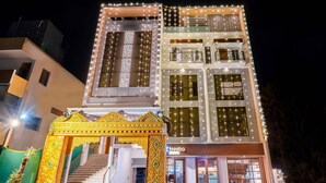 Un edificio de varios pisos con balcones y una entrada a nivel de calle.