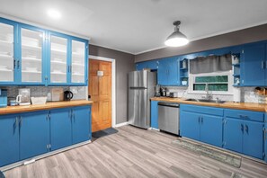 Una cucina moderna con mobili blu, elettrodomestici in acciaio inossidabile e un piano di lavoro in legno.