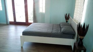 A bedroom with a bed, a window, and a door. - Beausejour Buena Vista Suite 4 (Gros Islet)