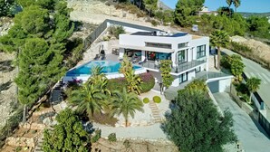 A modern villa with a swimming pool, surrounded by lush greenery and a hillside. - Villa Juno by Interhome (Jávea)