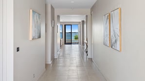 A hallway with a view to the outside, a door leading to a balcony, and artwork on the walls. - The Rosemary Lakehouse - Spring Offer (Yarrawonga)