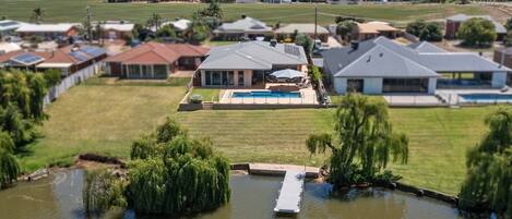 A residential area with houses, a swimming pool, and a dock over a body of water.