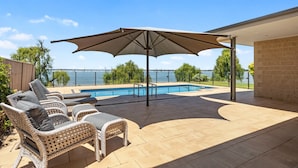 A patio with wicker furniture, a pool, and a view of the water. - The Rosemary Lakehouse - Spring Offer (Yarrawonga)