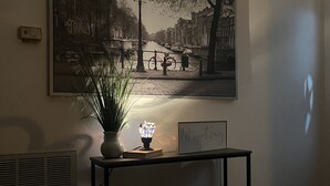 A room with a large framed picture of a canal scene, a small table with a plant and a candle, and a sign that reads "let's get creative". - Charming, cozy 3-bedroom country home in beautiful Seguin, TX (Seguin)