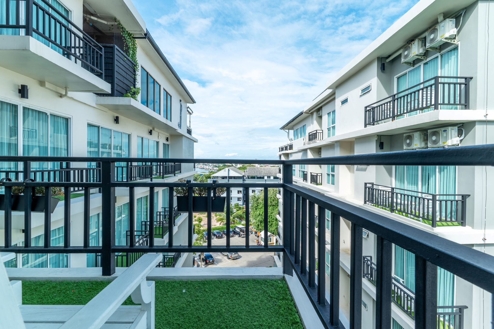 Un immeuble d’appartements moderne doté de balcons, de grandes fenêtres et offrant une vue sur la rue.