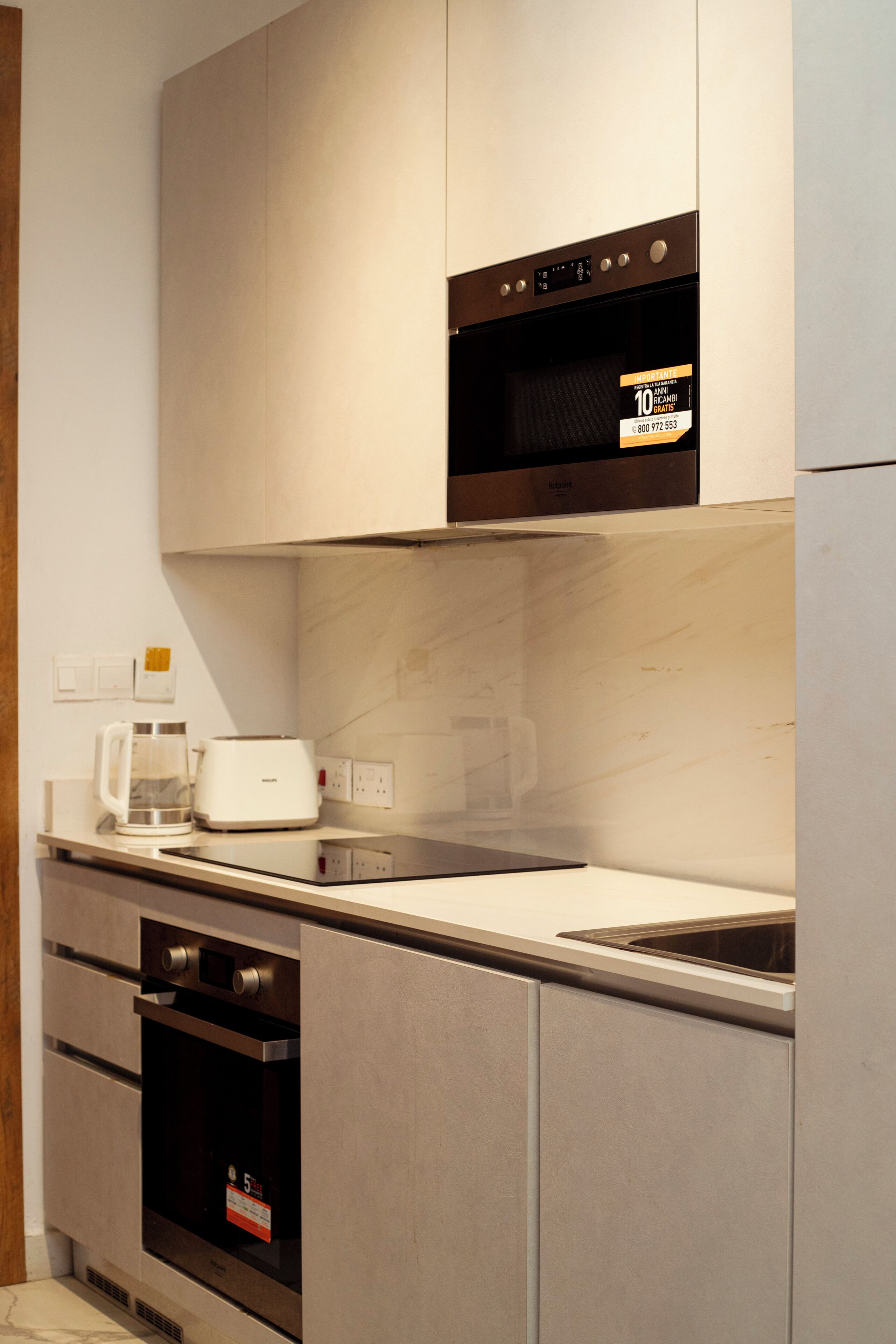 Cozinha moderna com eletrodomésticos embutidos, torradeira e máquina de café.