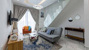 Ein modernes Wohnzimmer mit Sofa, Couchtisch und Fernseher.