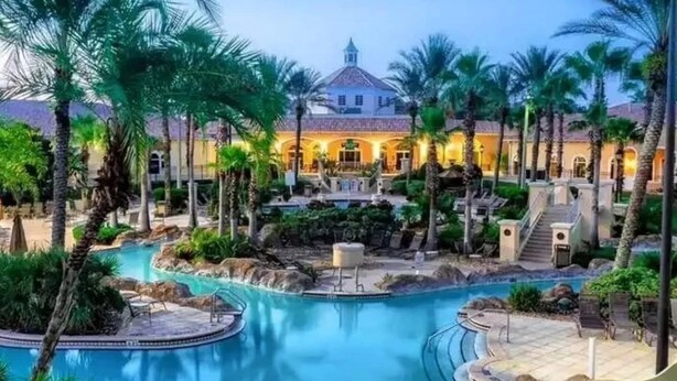 A resort with a large pool, palm trees, and a building with a dome roof. - Mario Kart Mayhem at Regal Palms Resort | Sage Vacations (Davenport)