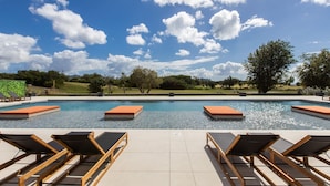 A swimming pool with lounge chairs and a view of the sky. - b703 (Cupecoy)