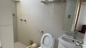 A modern bathroom with a toilet, sink, and shower. - LIMA HOUSE MILANI (Lima)