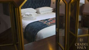 Un dormitorio con cama, almohadas y una toalla doblada.