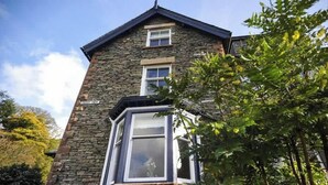 A stone building with a bay window and a door.