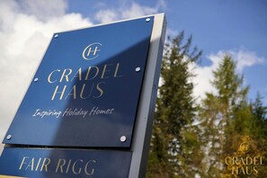 Un cartel para Cradel Haus con el eslogan 'Inspiring Holiday Homes' y el nombre 'Fair Rigg' debajo.