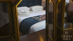 Une chambre d’hôtel avec un grand lit, une tête de lit et une table de chevet.