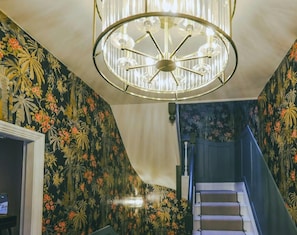 Experience unparalleled luxury in Windermere's hallway, captured in this photo showcasing stunning brass and glass light fittings, adding an extra touch of opulence and sophistication to the ambiance. - Luxe Duplex with EV Charger & Pet-Friendly (Bowness-on-Windermere)
