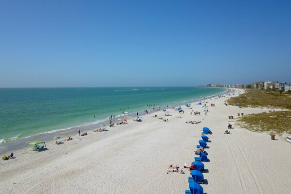Enjoy a serene beach experience with access to the ocean and shaded areas under the resort's umbrellas.